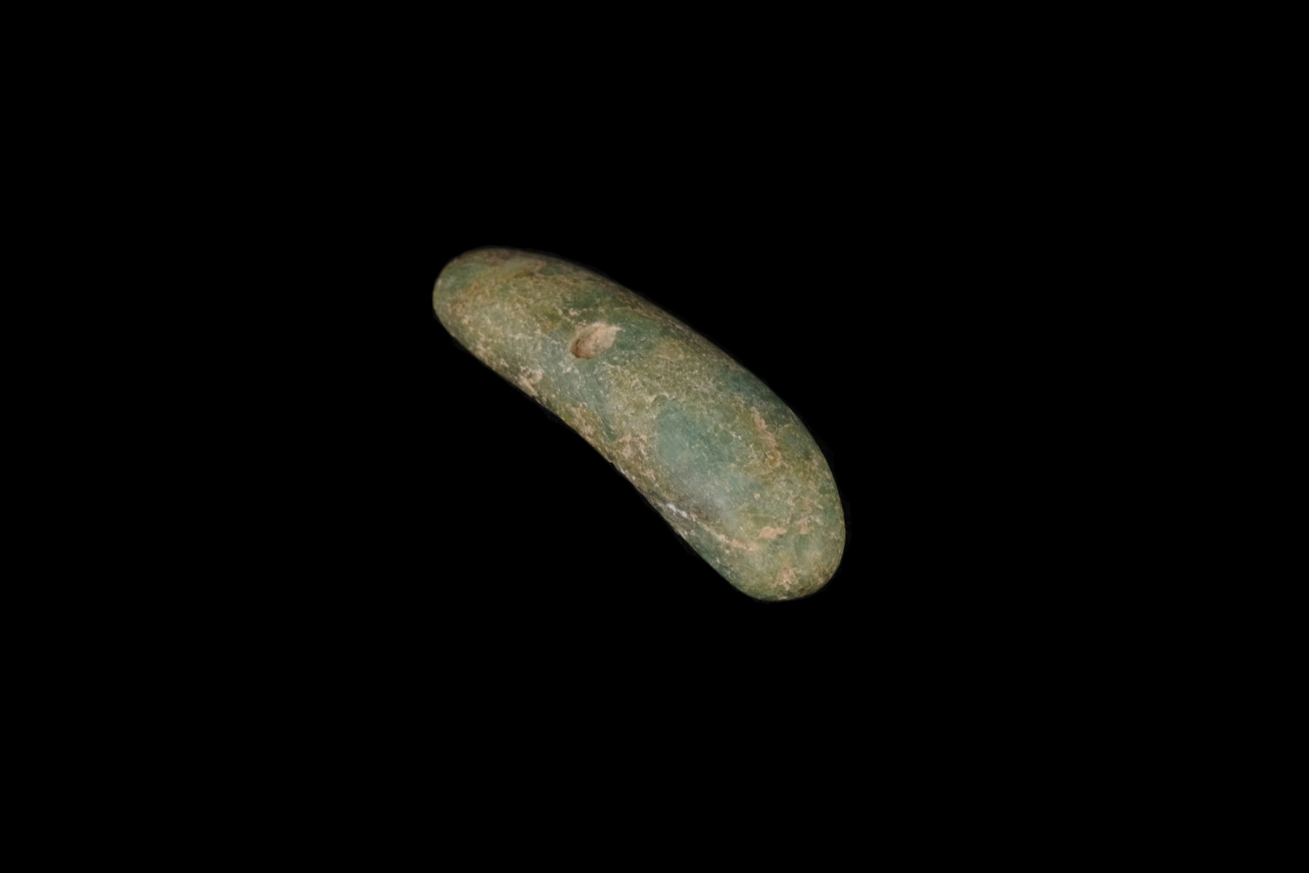 An oblong green stone, pierced