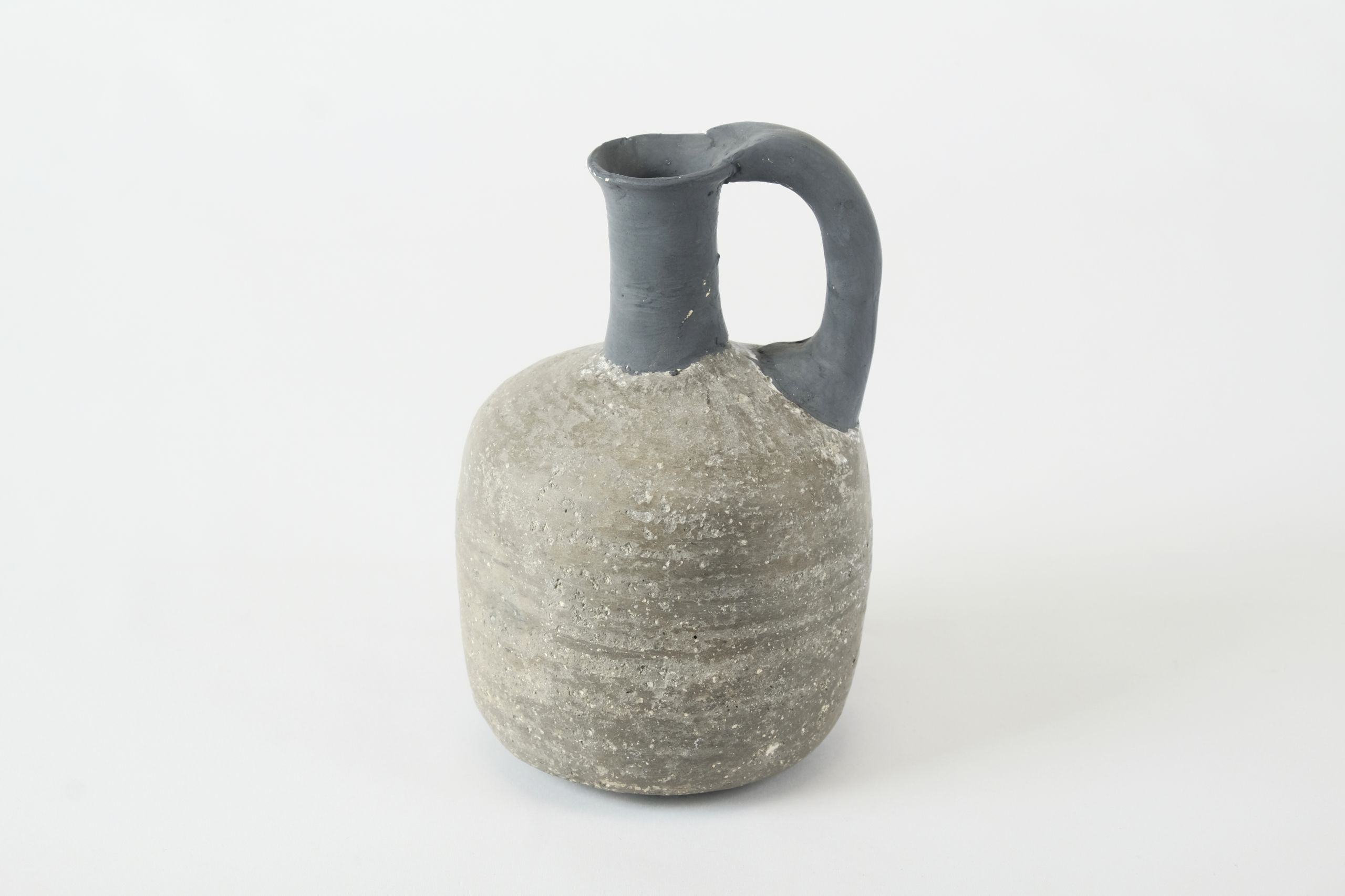 Grey juglet reconstructed with black plaster on the rim and handle