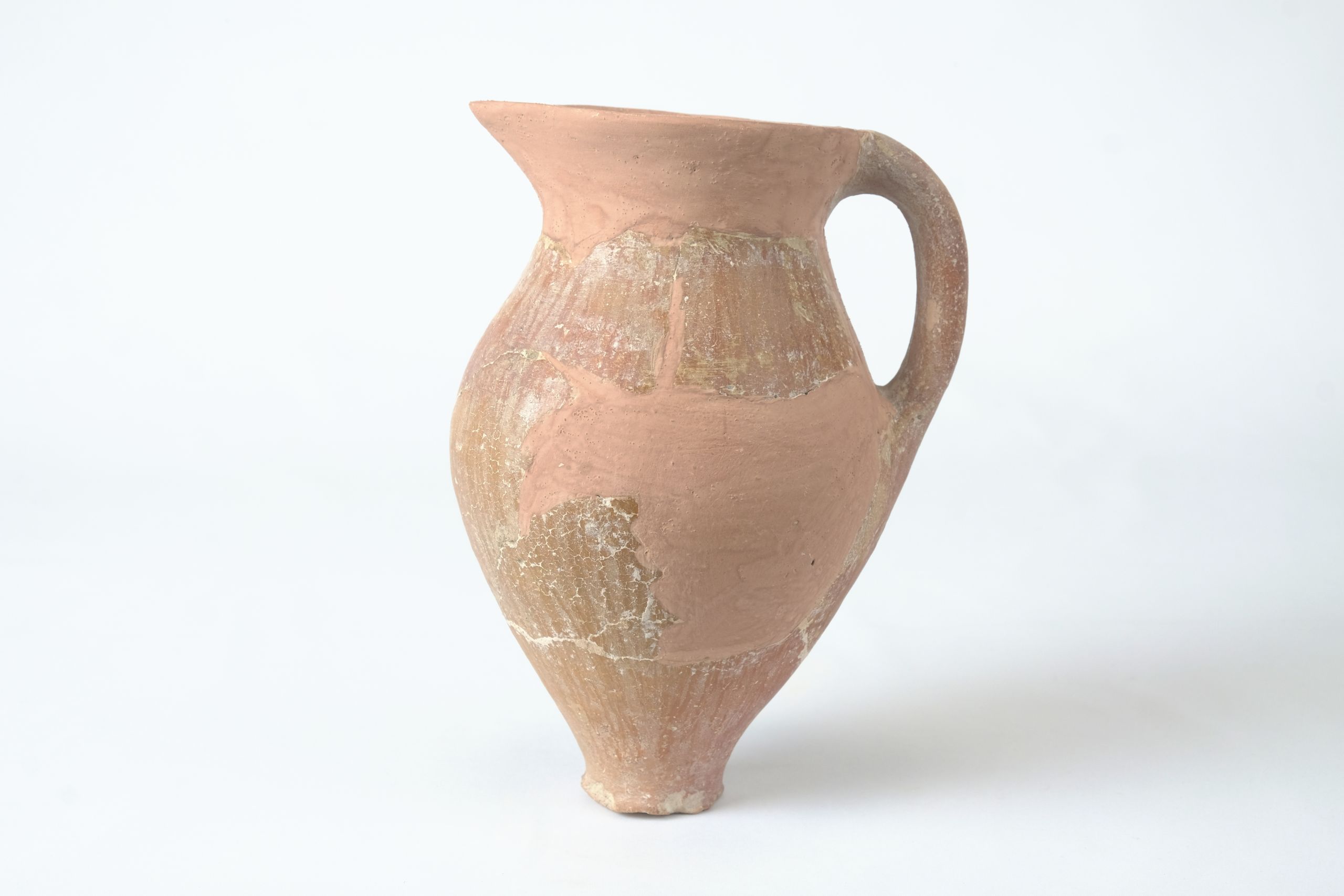 Tall jug with narrow base, reconstructed with tan plaster on the rim and body
