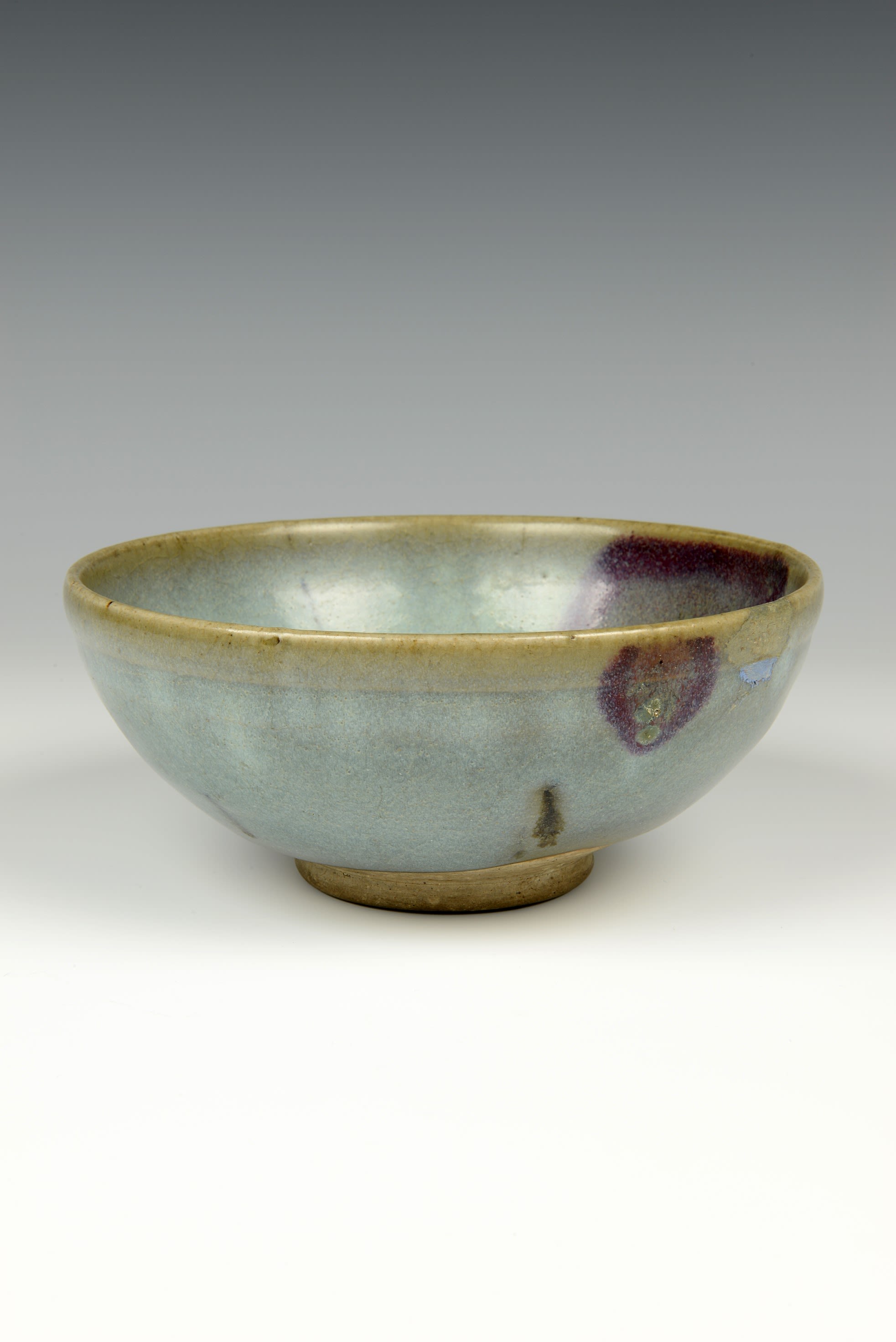 A simple dark green bowl with a golden trim around the top and base.