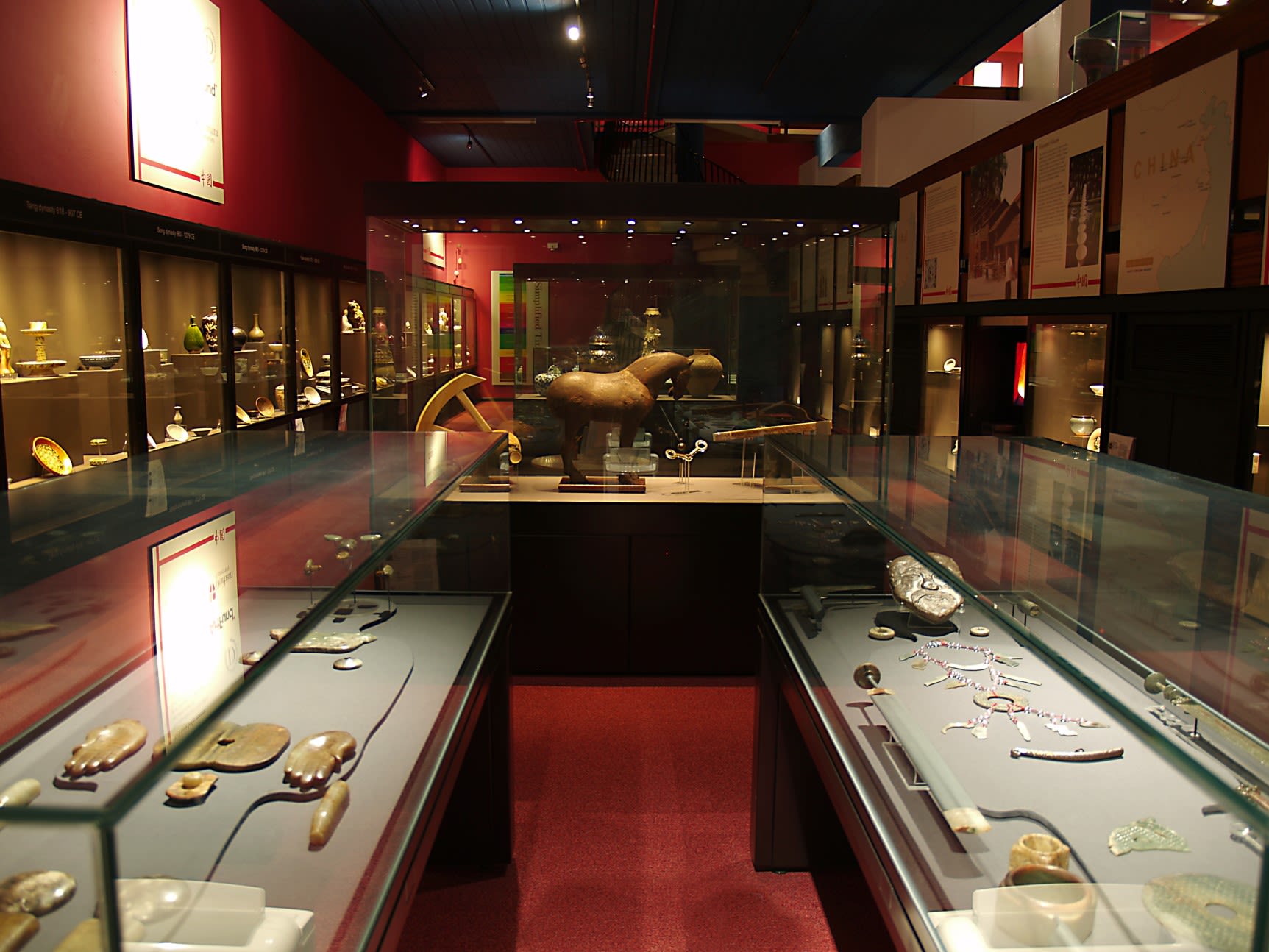 View of the MacDonald Gallery at the Oriental Museum, Durham, showing display cases with a variety of Chinese ceramics and sculptures
