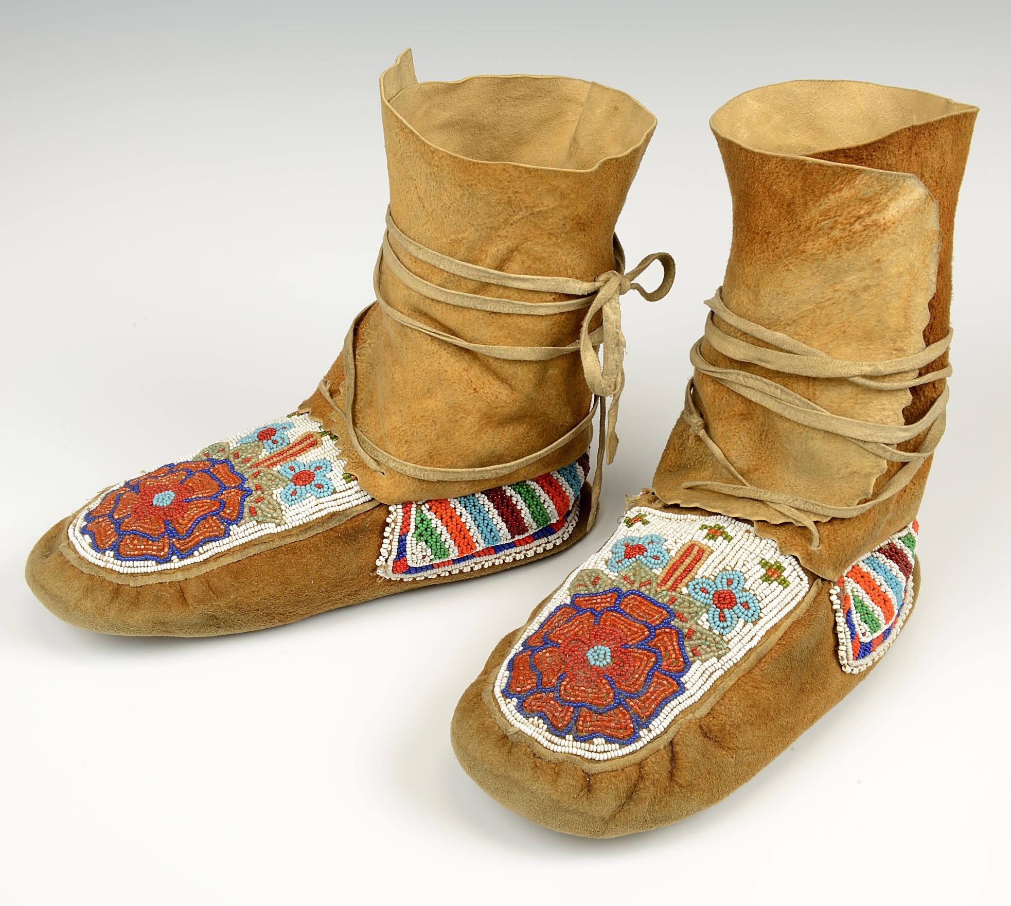 Brown boots with decorative floral patterns in red, white, green and blue.