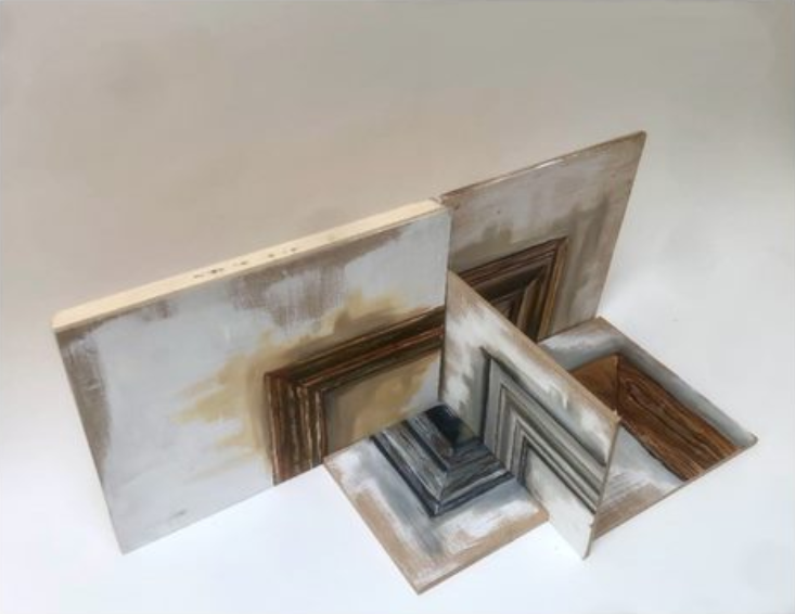 Four wooden boards, of various sizes, painted wash white with corners of traditional picture frames painted on them.