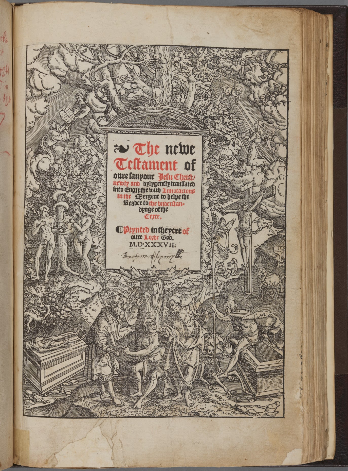 Large historic book, open to a title page reading 'The New Testament', surrounded by border of biblical imagery.