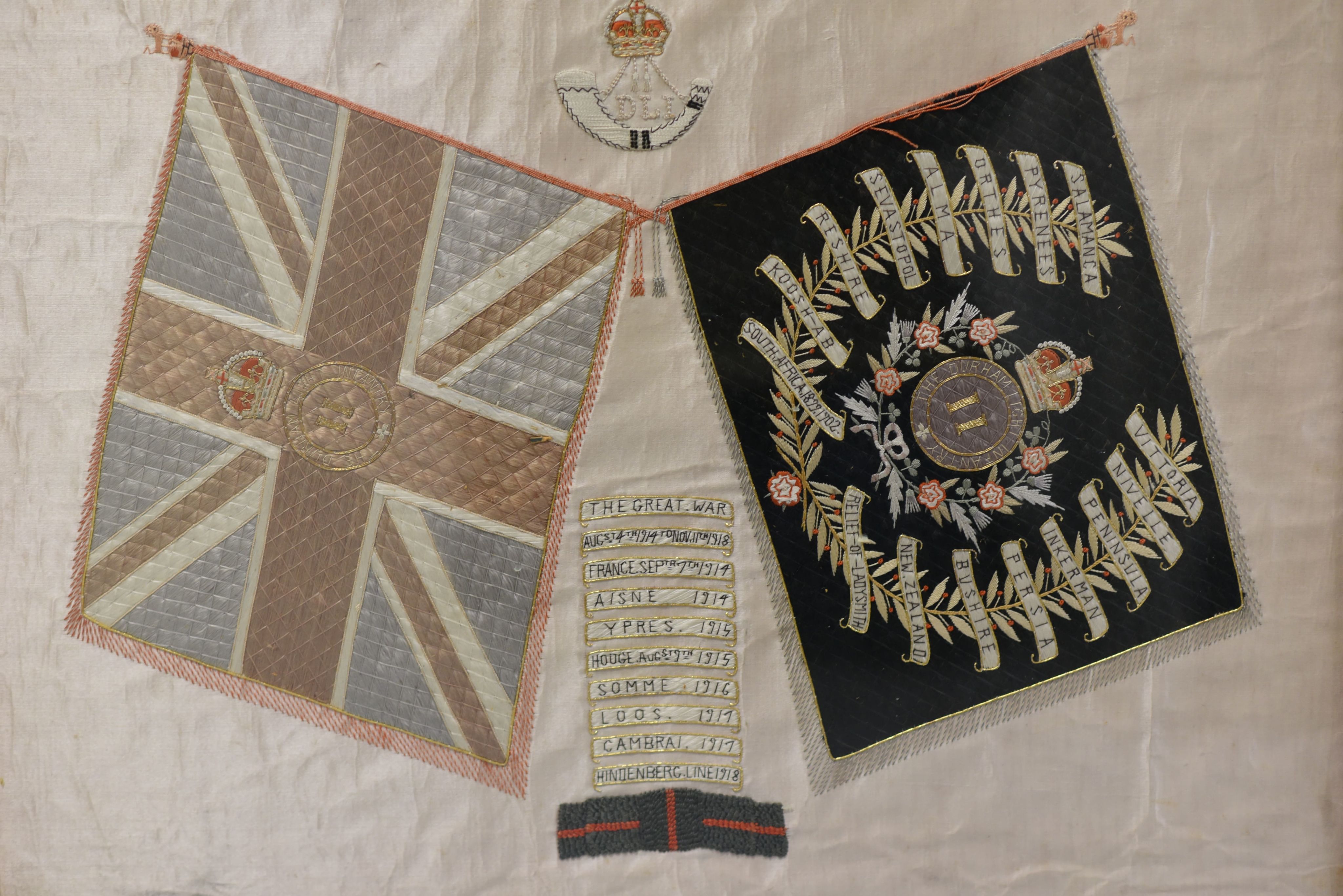 White silk rectangle with DLI crest embroidered. Below the crest are King's and Regimental Colours of 2 DLI.