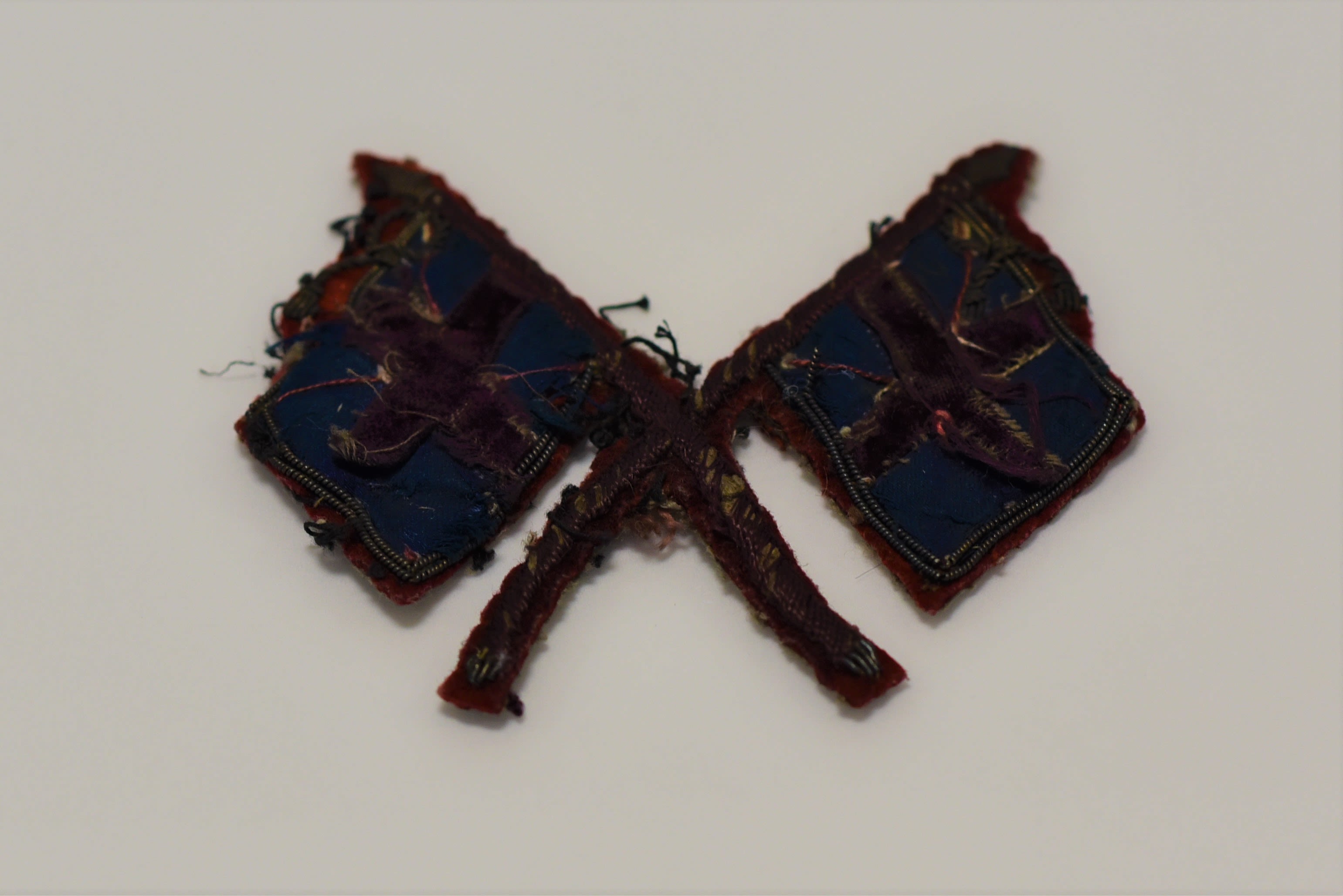 Small fabric badge designed in shape of set of Colours with crossed poles.